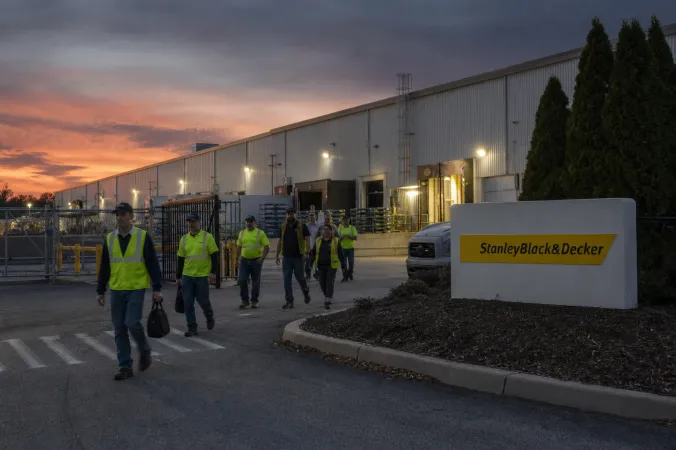 Exterior of a Stanley Black & Decker manufacturing facility in Hampstead, Maryland, with workers leaving at the end of a shift.