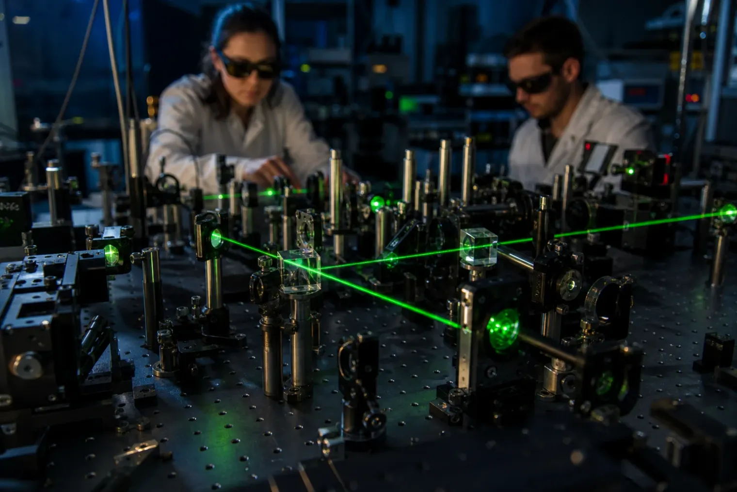 An optical quantum physics laboratory with a laser beam passing through lenses, mirrors and beam splitters on an optical table.